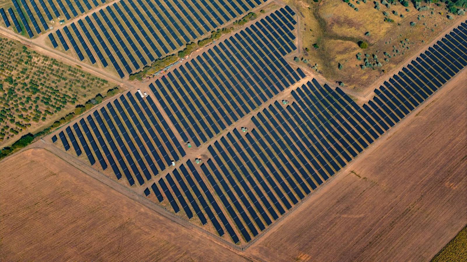 Vista aérea de una planta fotovoltaica entre campos de cultivo y olivares