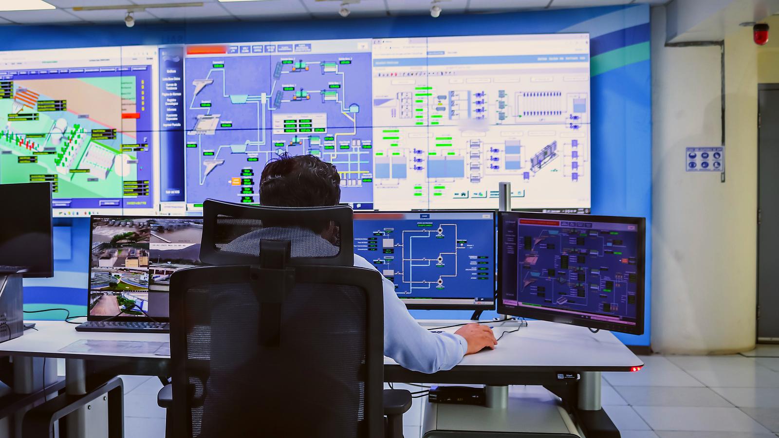 Operador en una sala de control con el SCADA de la planta en las pantallas
